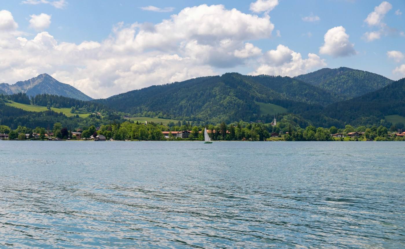 Lake Tegernsee with a sailing boat; which shore is not identified